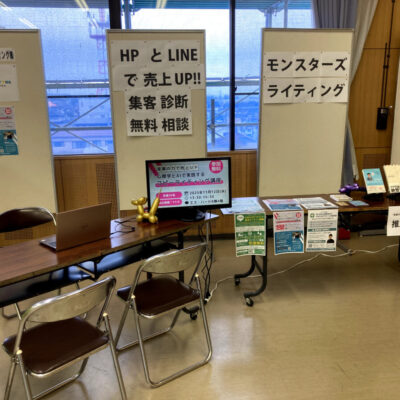 モンスターズライティング株式会社が第69回駒ヶ根商工まつりに出展した活動報告用の画像です。飯田市ホームページ制作を中心に地域事業者を支援する取り組みを紹介しています。