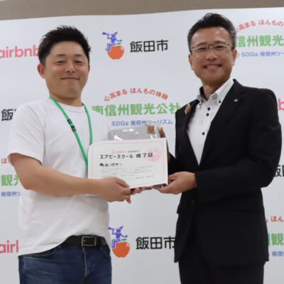 モンスターズライティング株式会社の佐伯怜司が参加した、飯田市で開催された空き家活用実践講座エアビースクールの様子を伝える画像です。地域の空き家課題と可能性を学ぶ内容の記事に使用されています。